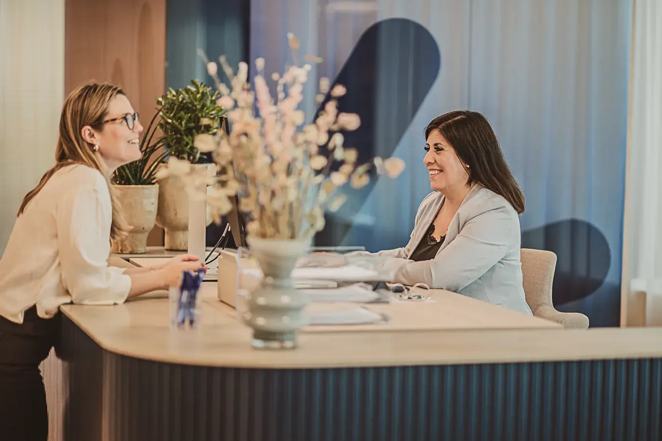 En besökare och Manpowers receptionist ler mot varandra över receptionsdisken